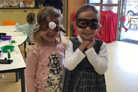 girls wearing masks made at playgroup